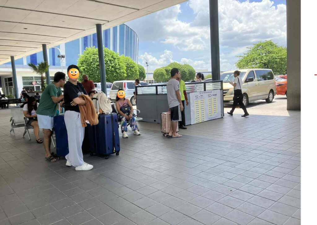 SMクラークのP2Pバス乗り場。時刻表前で待つ旅行者の様子