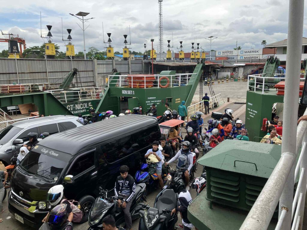 サマル島行きフェリーに乗り込む車やバイク。多くの乗客が待機