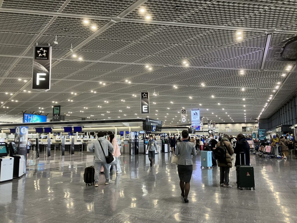 成田空港第1ターミナル南ウイングの出発ロビー全景。各航空会社のチェックインカウンターが並ぶ広いフロア。