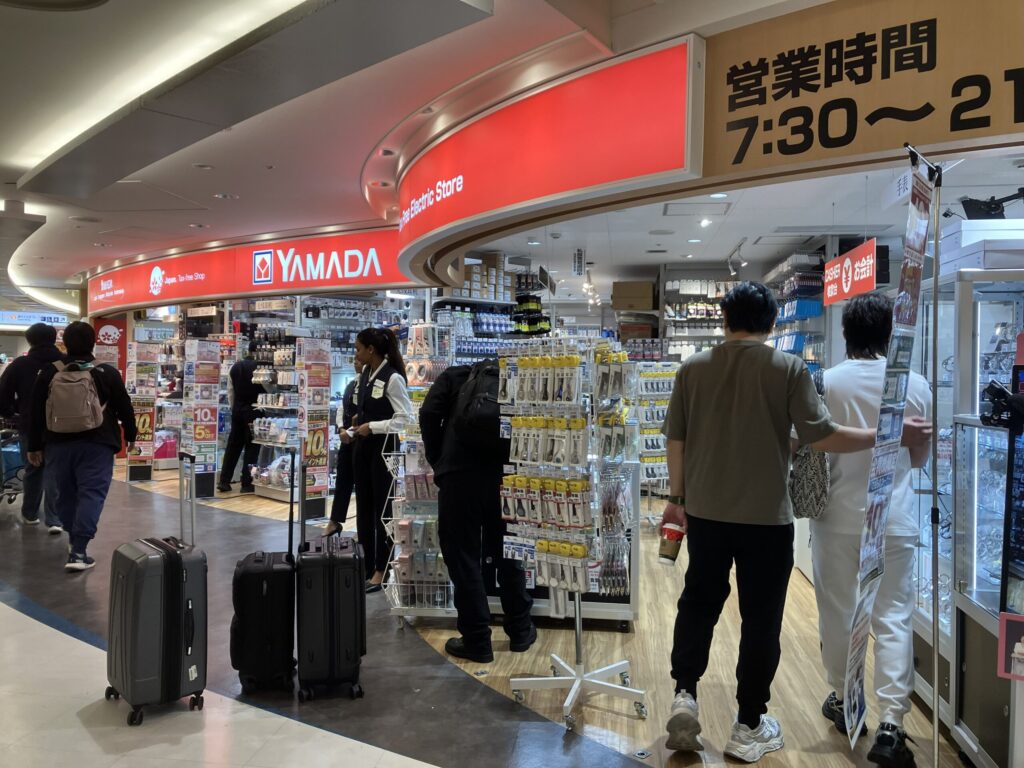 成田空港第1ターミナル4階のヤマダ電機店舗。旅行グッズや電子機器が並ぶ売り場。
