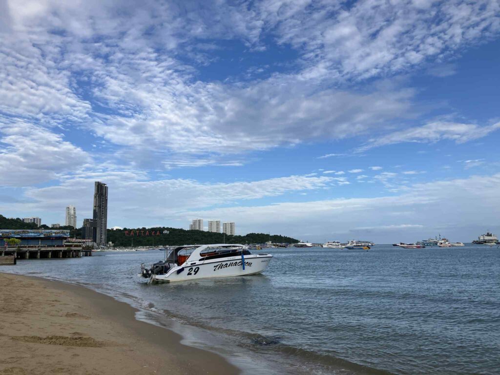 パタヤビーチ南側の海沿い風景。沖にはボートが浮かび、背景には「PATTAYA city」のサインが見える