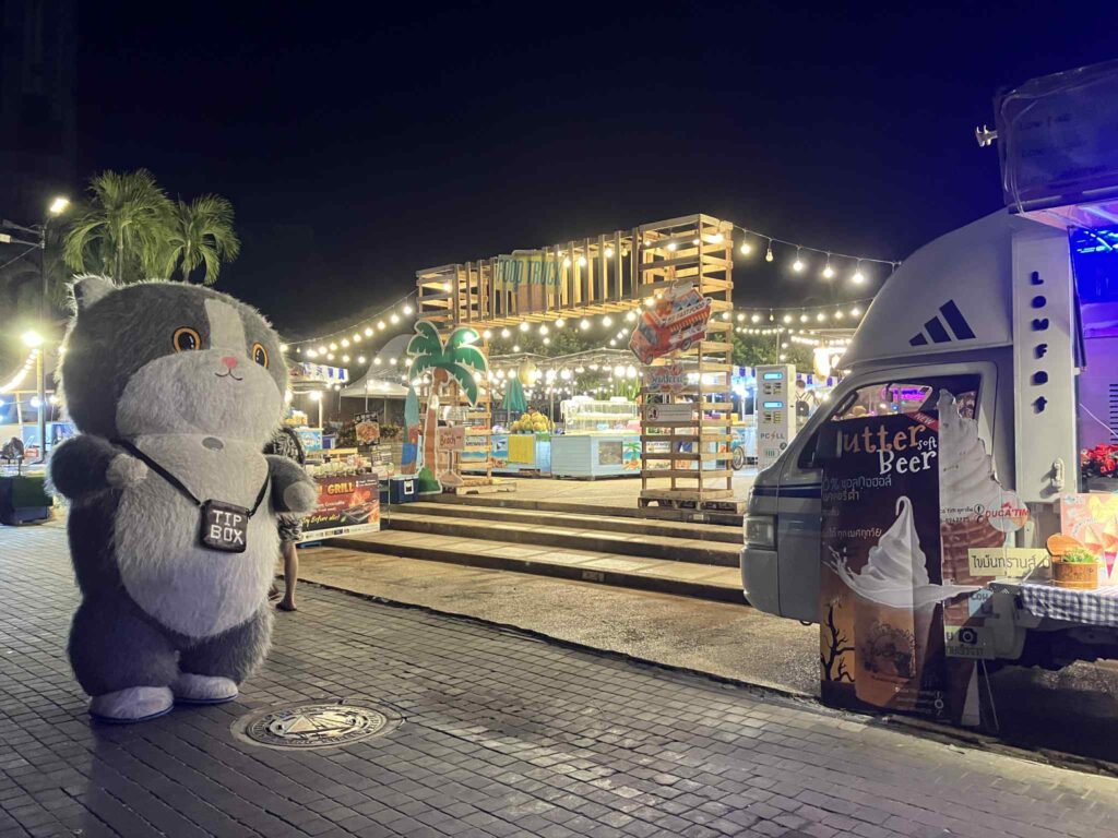 入り口付近に立つ着ぐるみマスコットとマーケット全体の夜景。