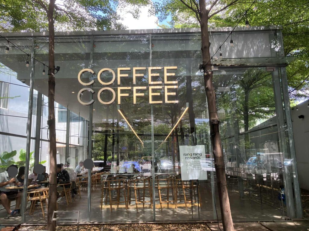 Rang Rang Coffee Thao Dienの外観。緑に囲まれた全面ガラスのモダンな建物。