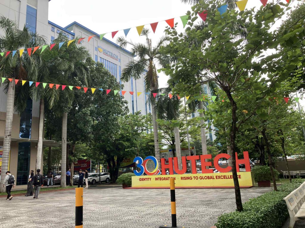 HUTECH大学のThu Ducキャンパス入口、30周年記念のカラフルな看板と校舎