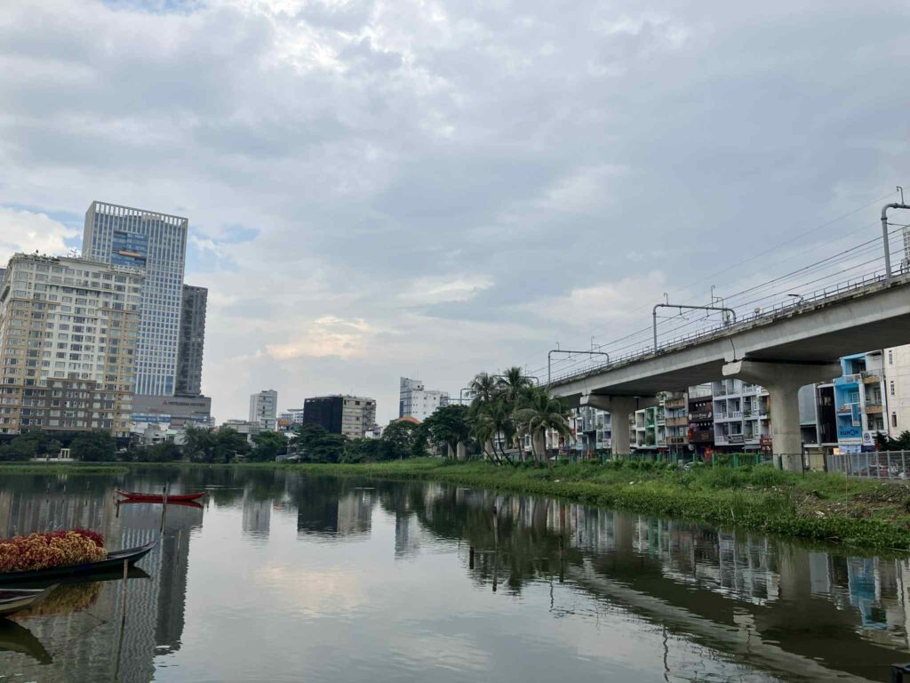Van Thanh公園の湖と遠くにそびえる高層ビル群と高架線