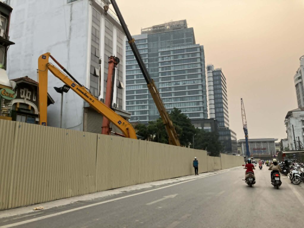 ハノイメトロ3号線ハノイ駅工事現場の長い仮囲いと重機(2026年4月)
