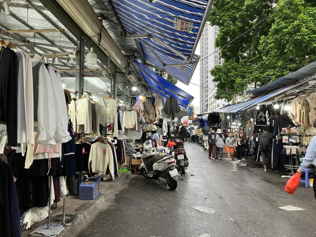 Nha Xanh市場の細い路地と衣料品店の並ぶ様子