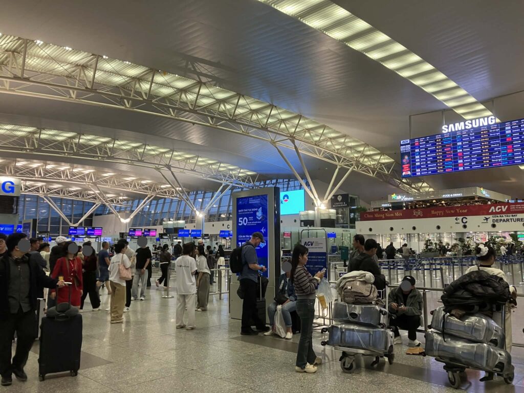 ノイバイ空港T2のチェックインカウンター前に並ぶ乗客