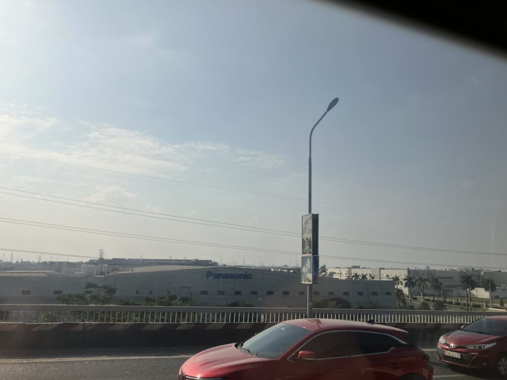 07番バスの車窓から映るタンロン工業団地のPanasonicベトナム工場。バスはThang Long橋を通過する。