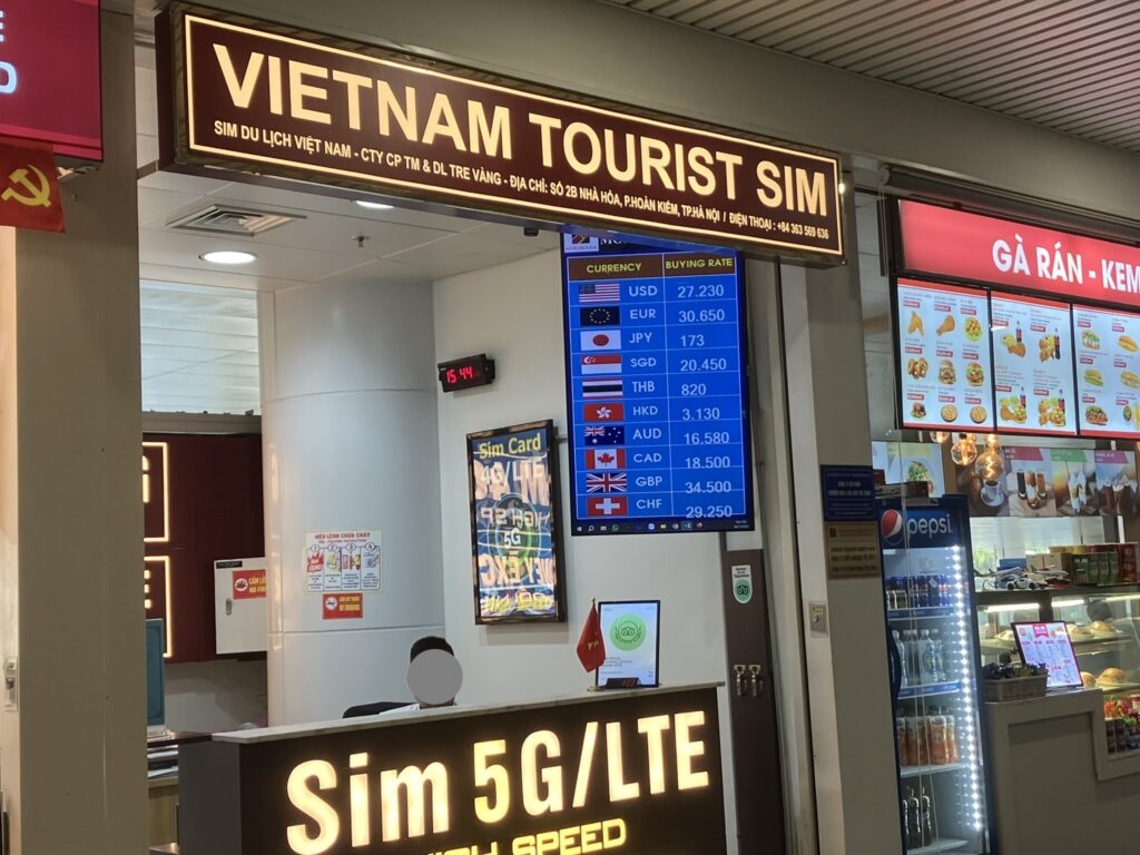 ノイバイ国際空港T2のVietnam Tourist SIMカウンターと掲示された両替レート