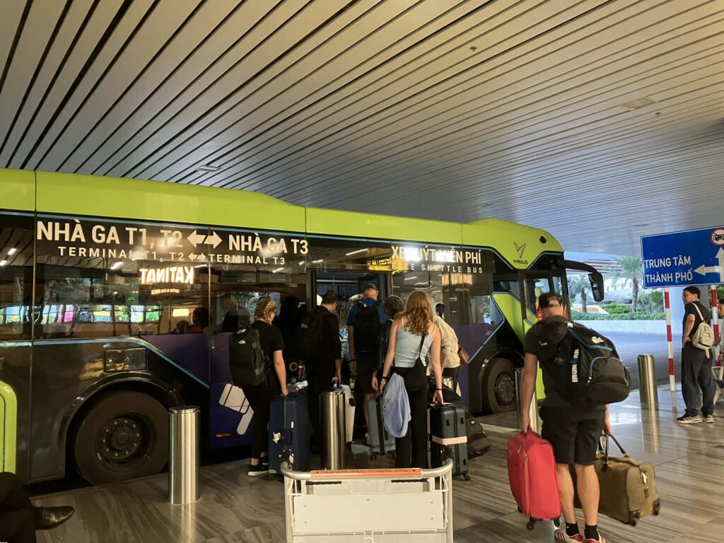 タンソンニャット空港T3でシャトルバスに乗車する利用者