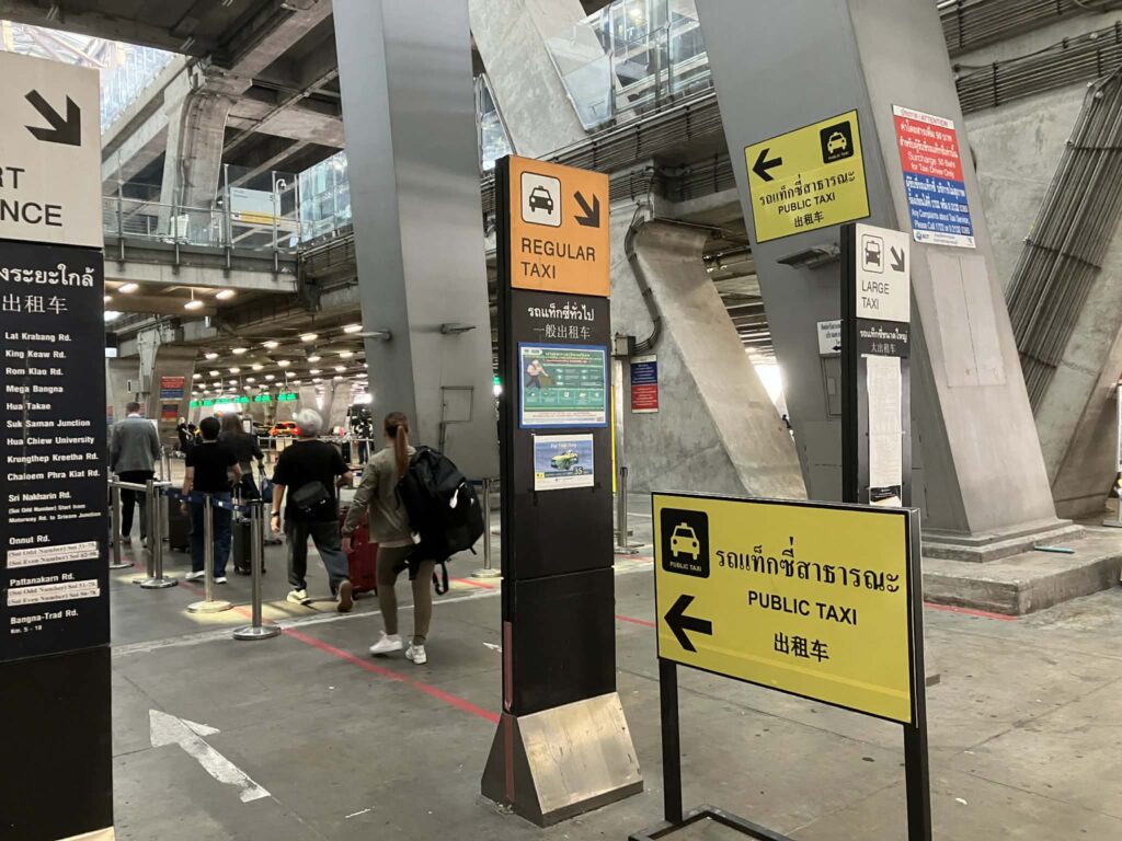 スワンナプーム空港1階の公共タクシー乗り場案内。Regular TaxiとPublic Taxiの表示