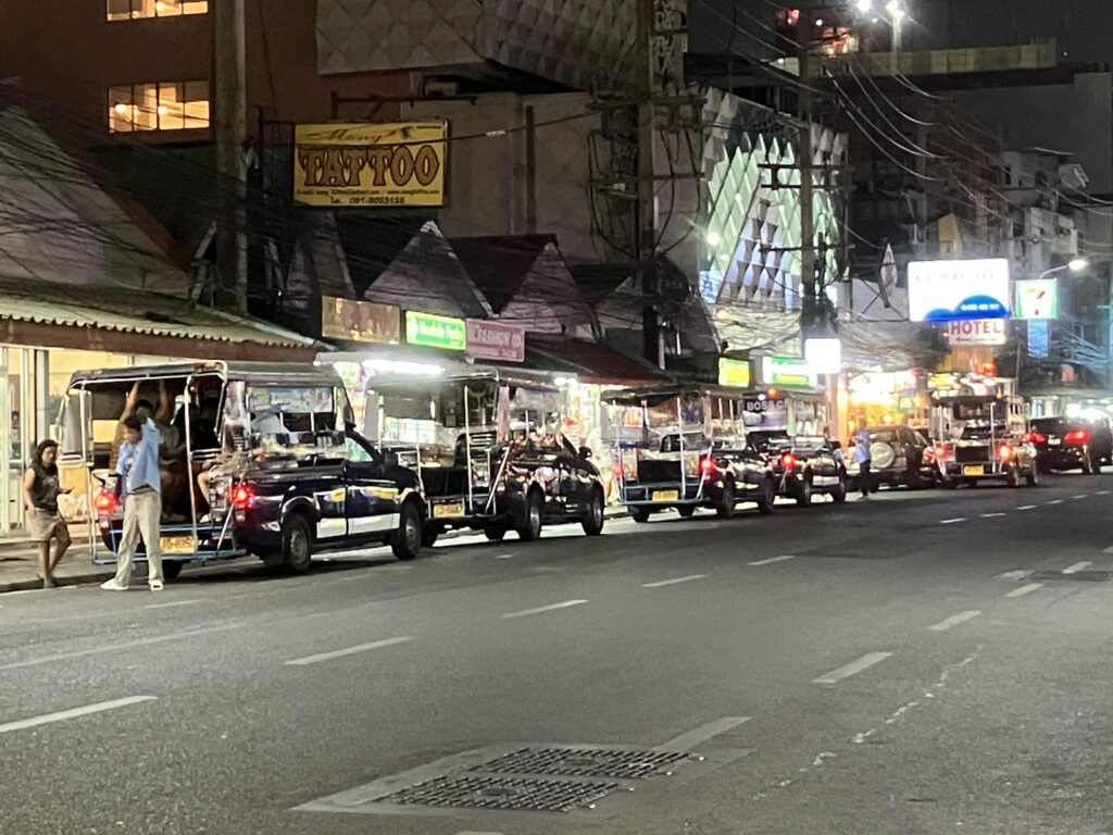夜のパタヤ市内で待機する複数台のソンテウ