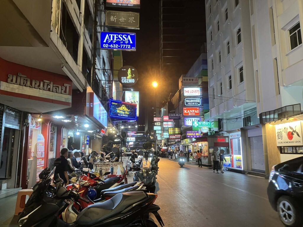 夜のタニヤ通りに並ぶ日本語看板と人通り