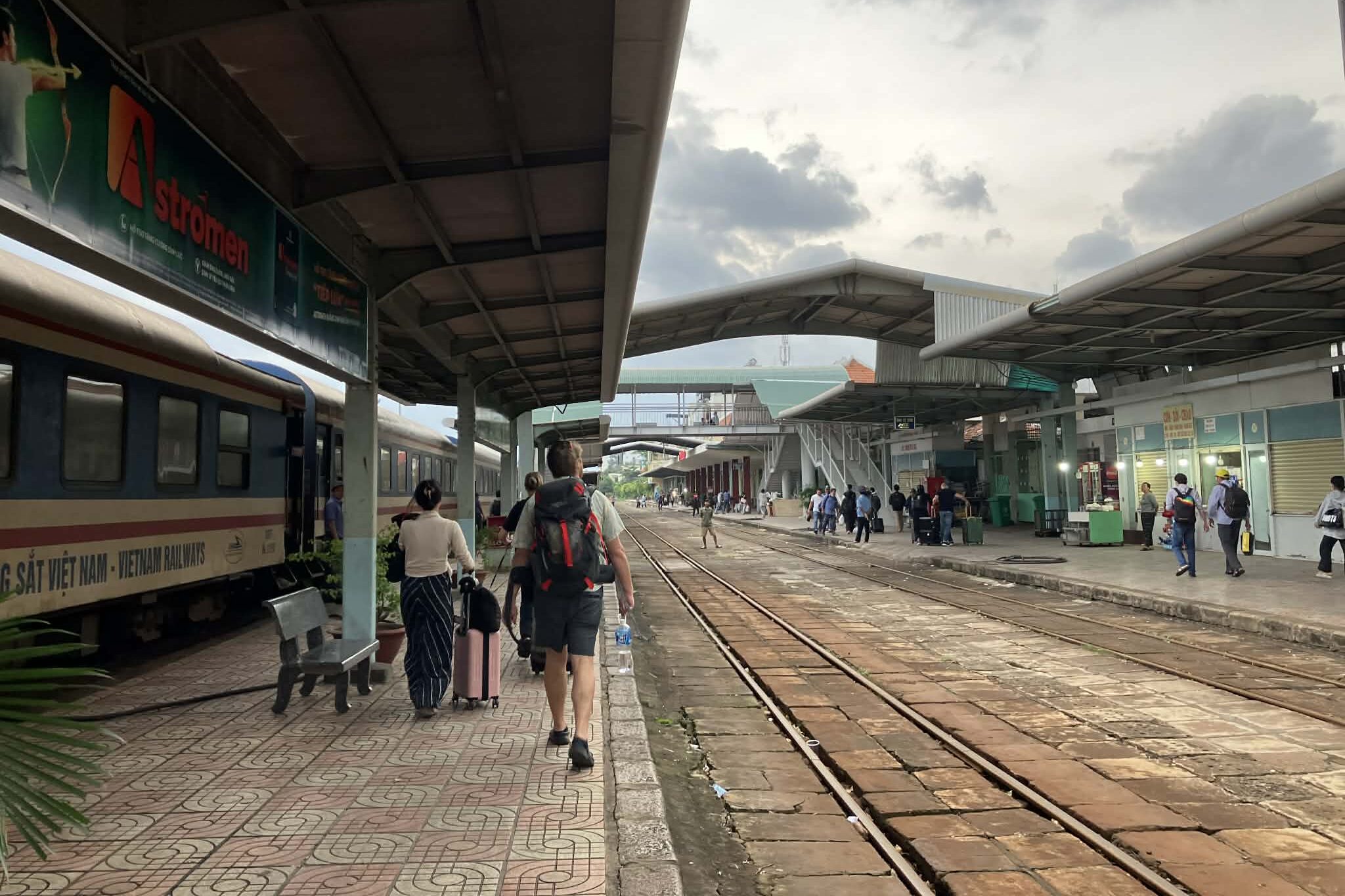 ニャチャン駅ホームを歩く乗客と列車