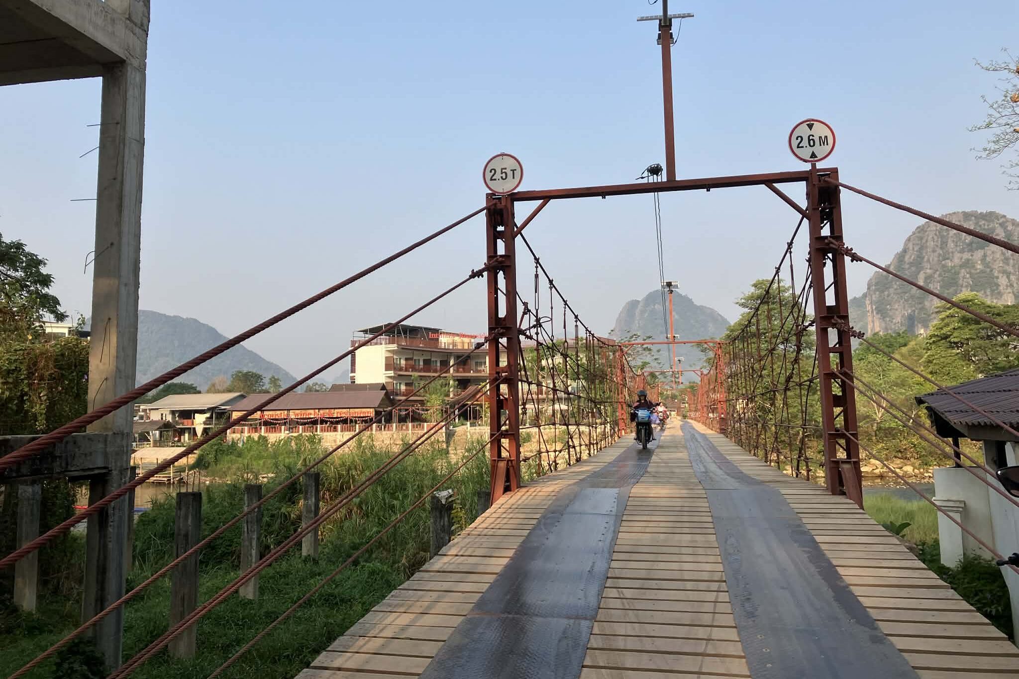 バンビエンの木製の橋をバイクで渡る様子