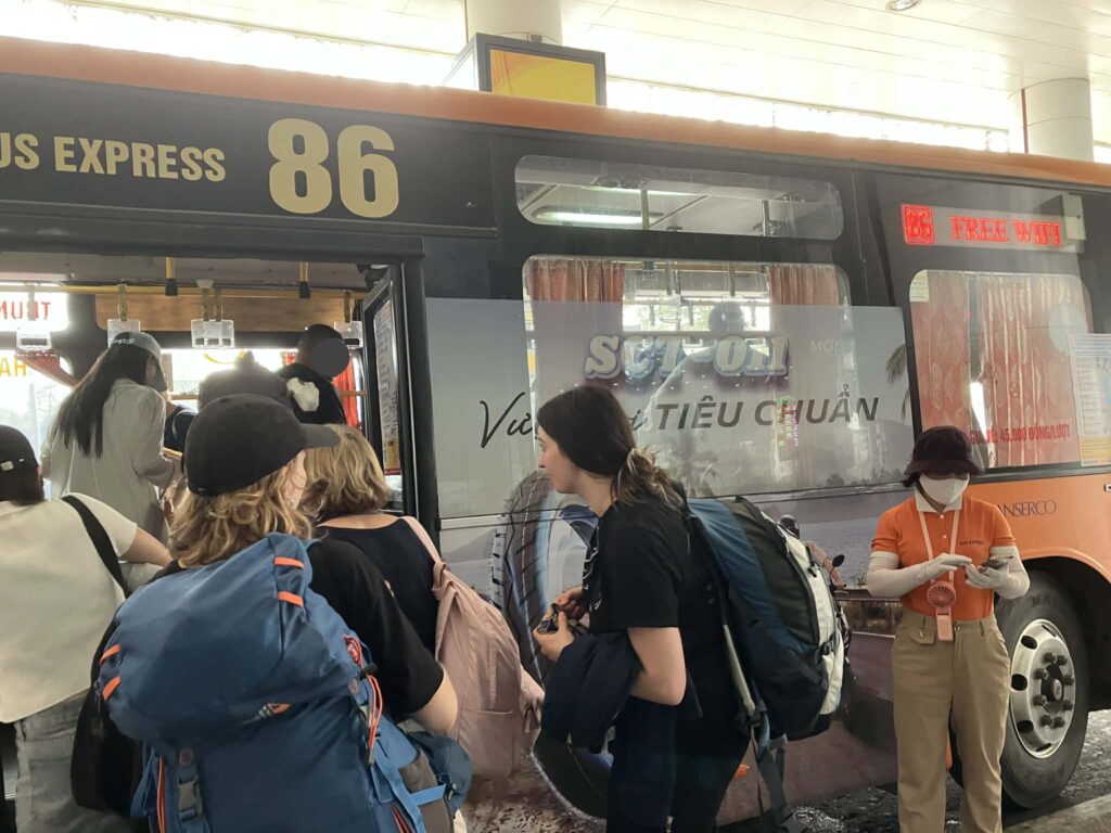 ノイバイ空港T2の86番バス乗車列｜スーツケースやバックパックを持った旅行者が並ぶ様子