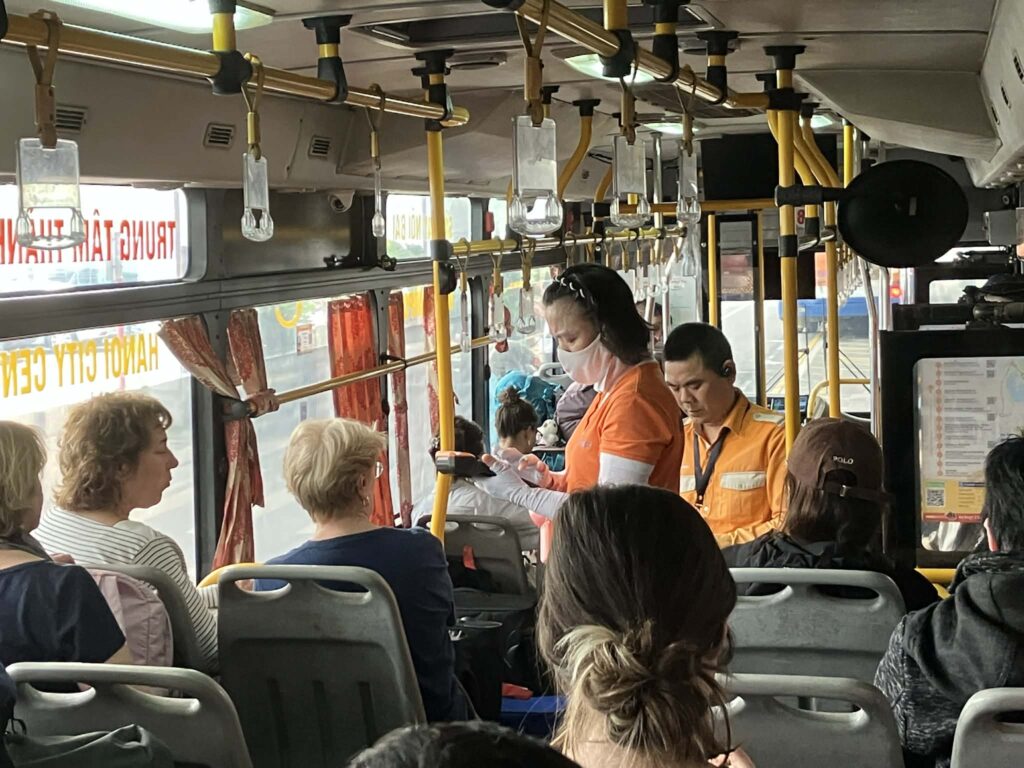 ハノイ86番バス車内での運賃徴収｜スタッフが出発前に料金を集める様子