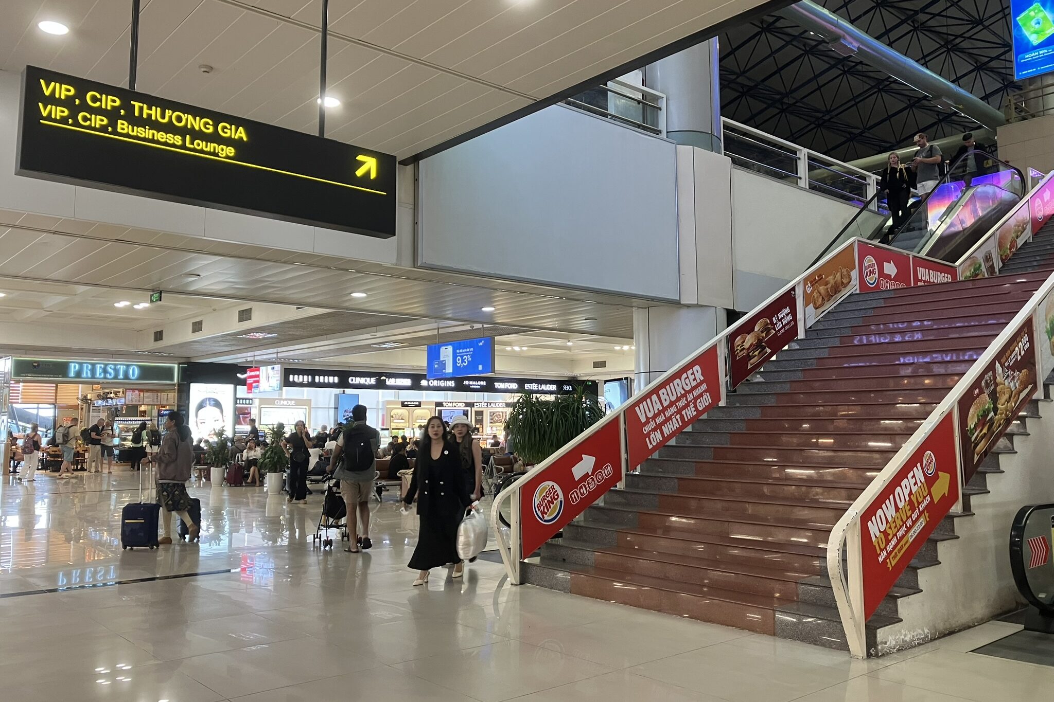 ノイバイ空港T1でVIP・CIPラウンジへ向かう通路。上部にラウンジ案内サインが掲示され、エスカレーター横の分かりやすい位置にある。