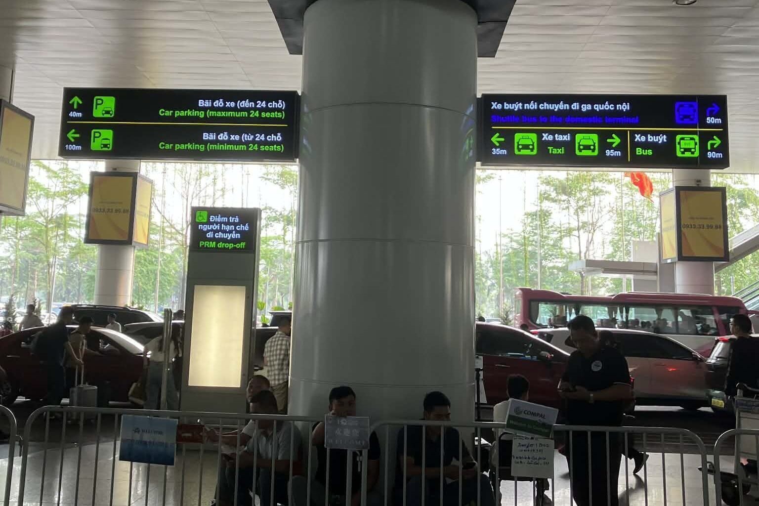 ノイバイ空港T2到着フロア出口付近の交通案内看板（タクシー・バス・Grab乗り場）