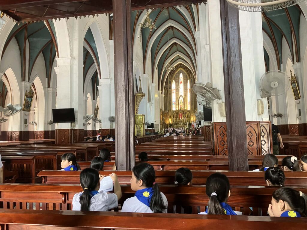 So Kien教会の内部とミサに参加する子どもたち