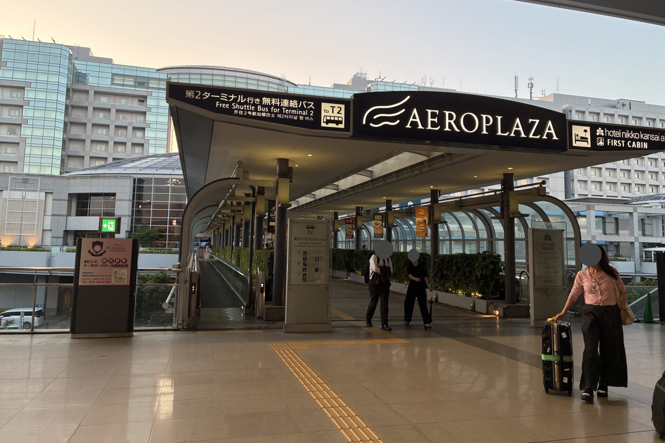 関西空港駅からエアロプラザへ続く連絡通路と第2ターミナル行き無料連絡バスの案内