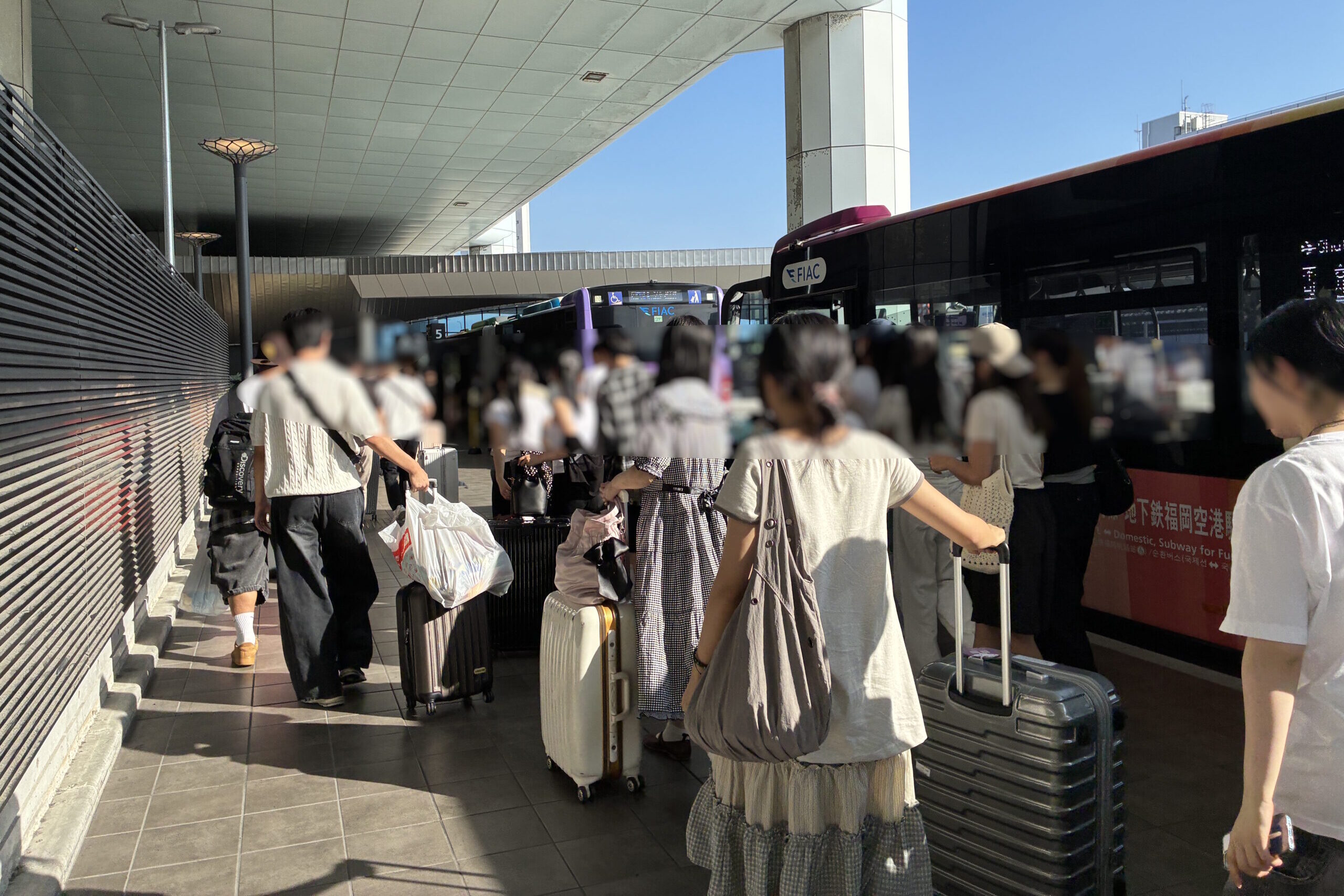 福岡空港国際線ターミナルに到着した無料連絡バスから降りる乗客